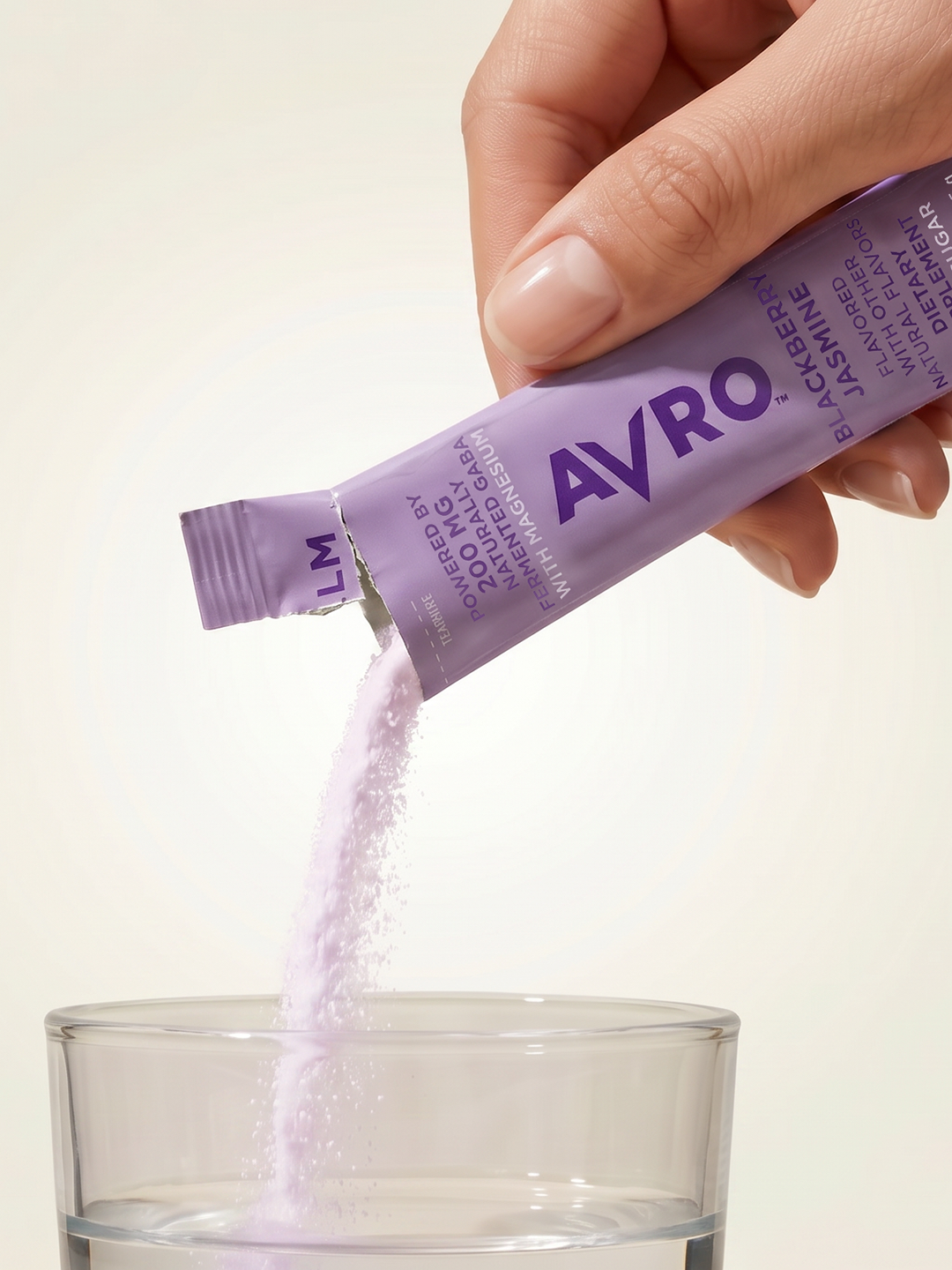 Pouring an AVRO Calm stick into a glass of water