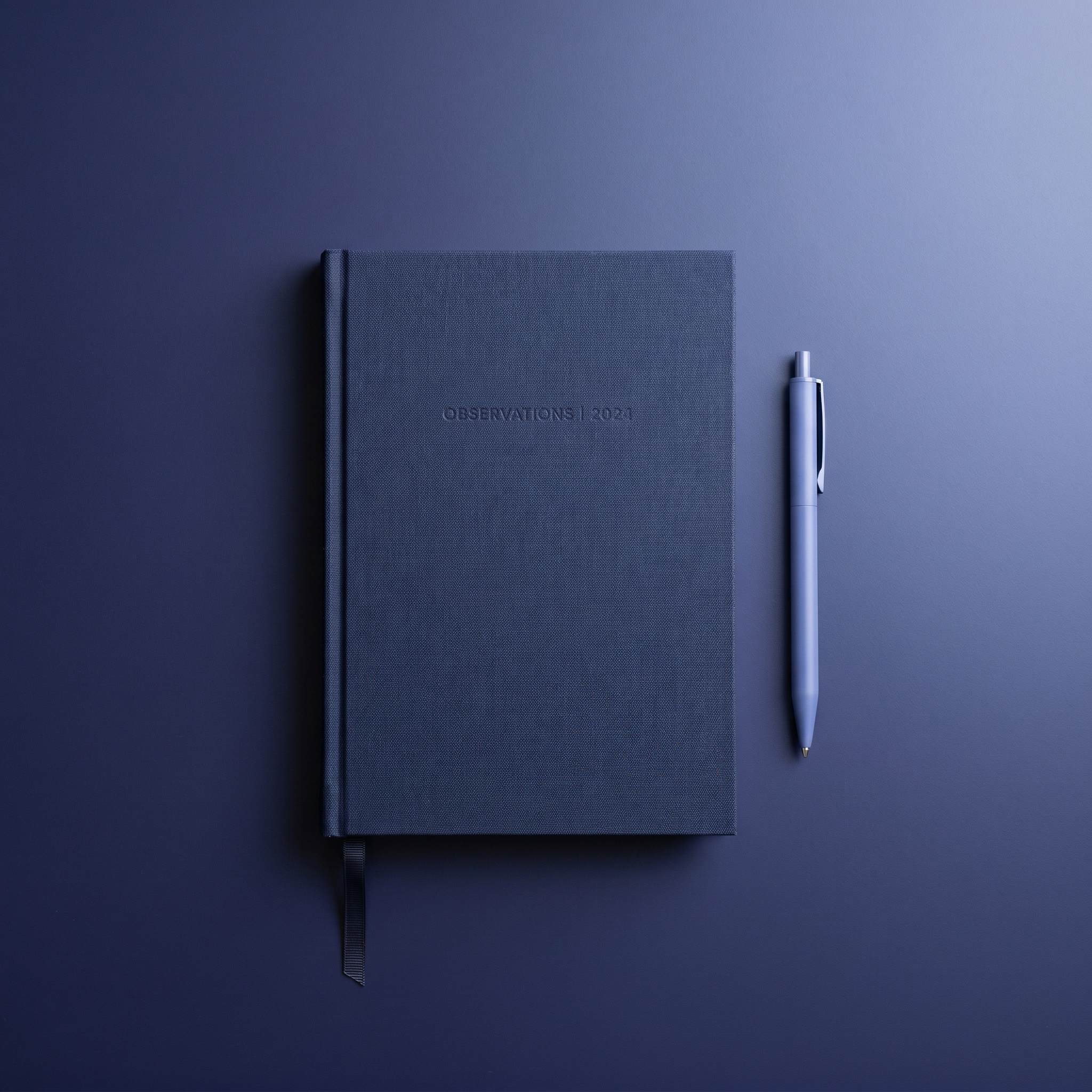 Navy notebook and pen on a desk